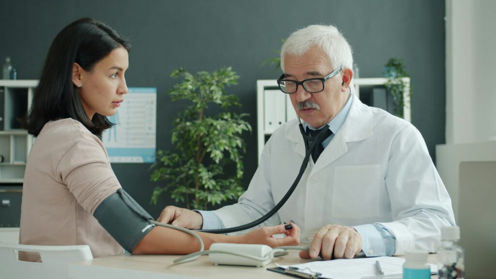 Doctor checking a patient’s blood pressure during a wellness exam
